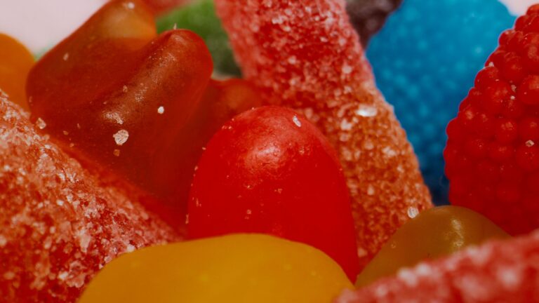 Vibrant assortment of sugary gummy candies up close, showcasing textures and colors.