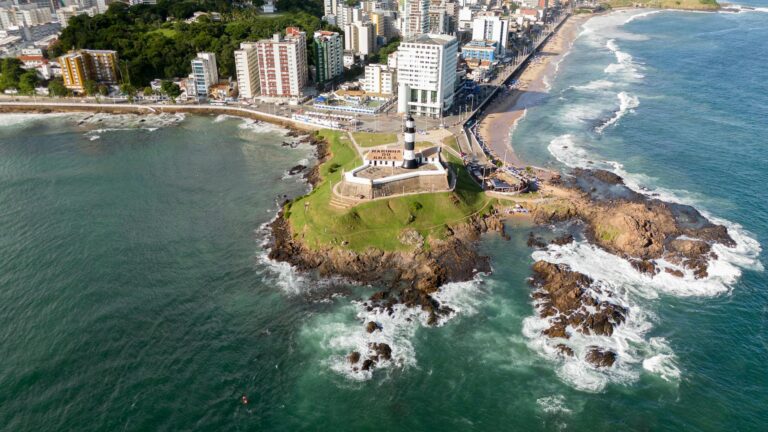 A stunning aerial view of Barra Lighthouse in Salvador, capturing the coastline and cityscape.