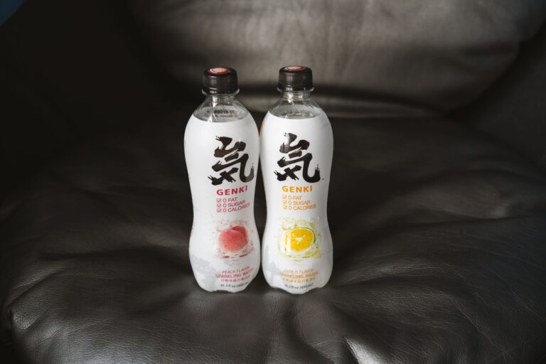 Close-up of Genki flavored sparkling water bottles placed on a leather couch, showcasing packaging and design.