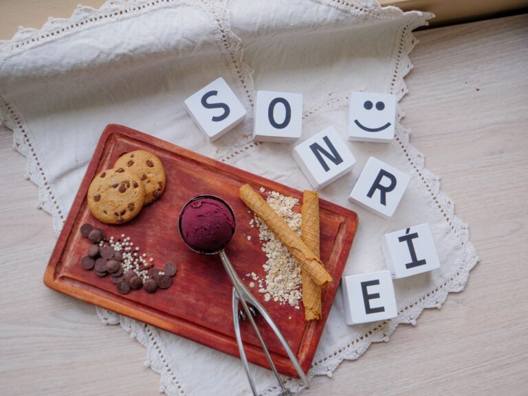 Flat lay of cookies, ice cream scoop, and word "SONRÍE" blocks. Ideal for food photography lovers.