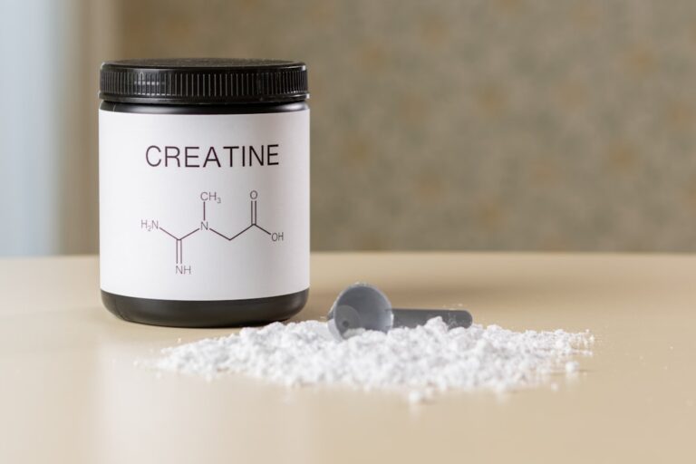 Uma Garrafa De Creatina Ao Lado De Uma Colher Em Uma Mesa E333ulMOZ_o